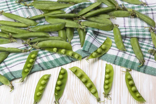 Ahşap masa üzerinde yeşil bezelye.