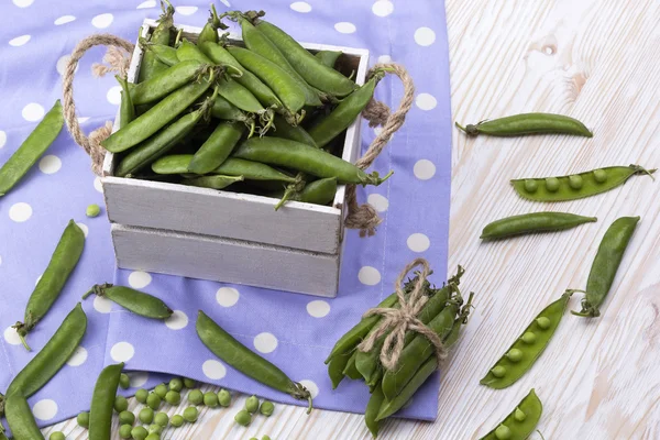 Groene erwten in een houten doos — Stockfoto