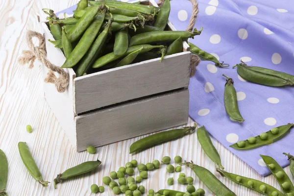 Groene erwten in een houten doos — Stockfoto