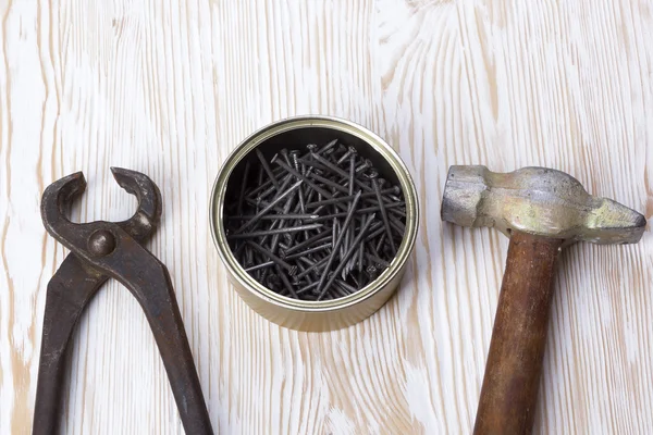 Hammer, pliers and metallic nails.