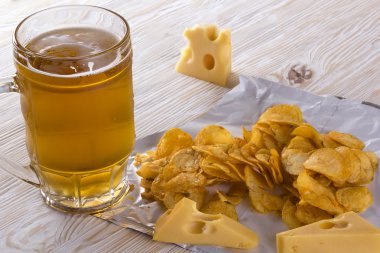 Patates cipsi, peynir ve bardak bira.