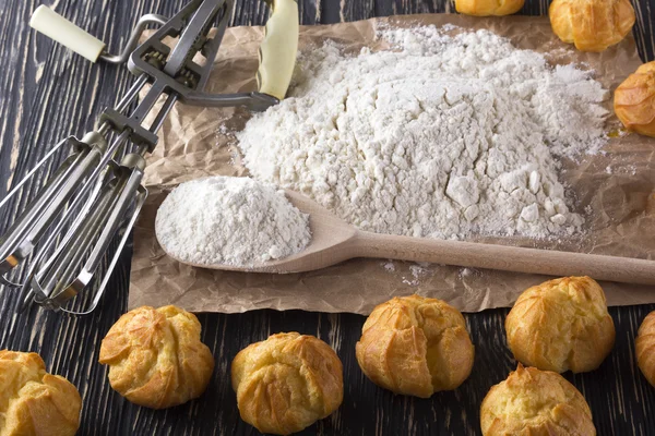 Smakelijke eclairs, eieren, bloem en omgaan met mixer. — Stockfoto