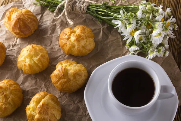 Eclair, koffiekopje en charmomile. — Stockfoto