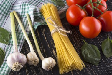 Pişmemiş makarna ve domates, fesleğen, sarımsak malzemelerle.