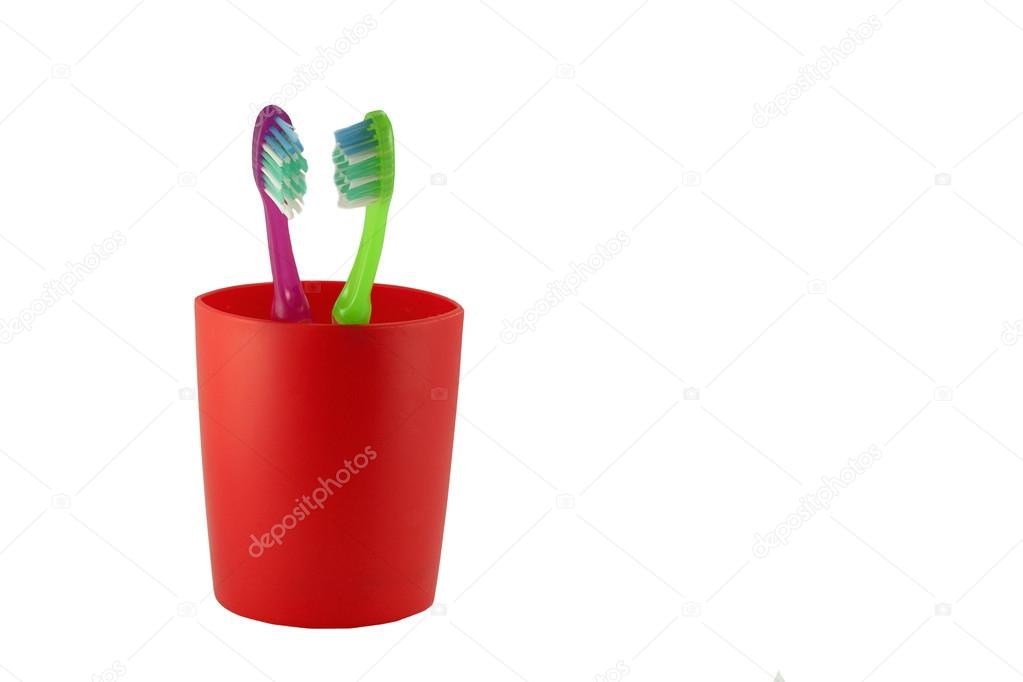 two tooth brushes in red glass