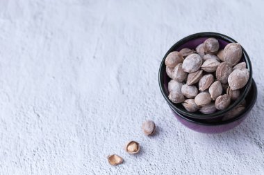 Masadaki küçük bir kasede tuzlu kayısı çekirdeği. Dona shurak Özbek Milli Gıda.