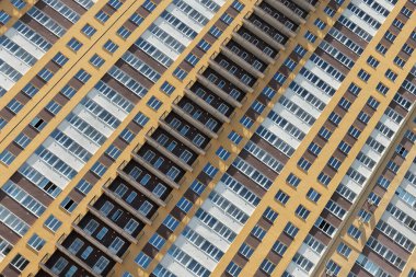 Pencereleri ve balkonları olan çok katlı bir bina. Geometrik soyutlama.