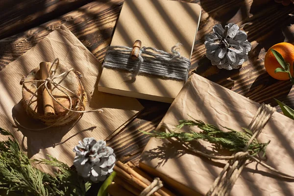 Chic cozy craft gift boxes on wooden background. Natural aestetic. Zero waste, plastic free, trendy hand made gift package for Christmas.