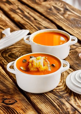 Baharatlı vejetaryen baharatlı balkabağı kreması çorbası beyaz kocotte ile birlikte kızarmış ekmek ve kabak çekirdeği ile servis edilir. Mevsimlik sonbahar vejetaryen yemekleri.