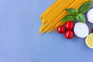 Spagetti, kiraz domatesleri, soğan, fesleğen, limon İtalyan makarnası için en iyi malzemeler. Sağlıklı gıda konsepti.