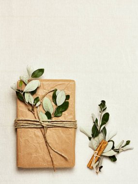 Çarşaf arkaplanına geri dönüşümlü el işi kağıda sarılmış moda bir hediye kutusu. Doğal estetik. Şık, rahat, sıfır atık, Noel, doğum günü, Paskalya için ücretsiz plastik el yapımı hediye paketi.