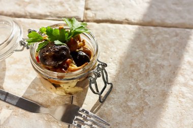 Cam kavanozda marine edilmiş mantarlar. Beyaz arka planda. Konserve sebze yemeği. Doğal ışık. Seçici odak.