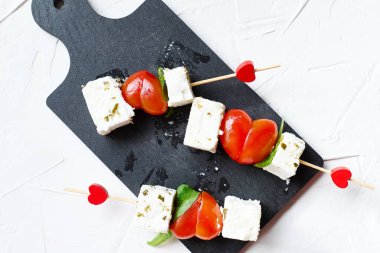 Sevgililer Günü ya da doğum günü romantik atıştırmalıkları. Peynirli ve kalp şeklinde domatesli kanepeler. Sevgililer Günü için orijinal yemek.