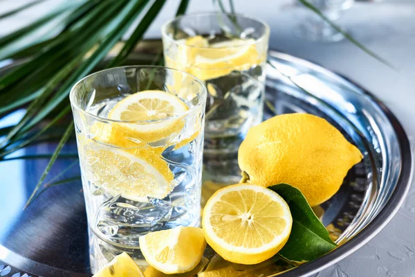Çelik tepside limonatalı iki bardak. Limon detoks içeceği, yaz aylarında alkolsüz kokteyl.
