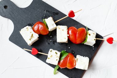 Sevgililer Günü ya da doğum günü romantik atıştırmalıkları. Peynirli ve kalp şeklinde domatesli kanepeler. Sevgililer Günü için orijinal yemek.