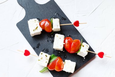 Sevgililer Günü ya da doğum günü romantik atıştırmalıkları. Peynirli ve kalp şeklinde domatesli kanepeler. Sevgililer Günü için orijinal yemek.