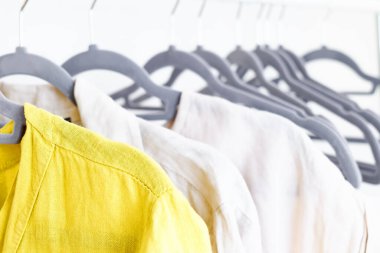 Gri askıların üzerindeki çarşaf elbiseleri. Slow Fashion. Bilinçli tüketim. Moda endüstrisinde kriz, perakende. Çevre dostu, sürdürülebilir satış konsepti. Sıfır kayıp. Kara Cuma.