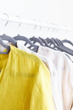 Gri askıların üzerindeki çarşaf elbiseleri. Slow Fashion. Bilinçli tüketim. Moda endüstrisinde kriz, perakende. Çevre dostu, sürdürülebilir satış konsepti. Sıfır kayıp. Kara Cuma.
