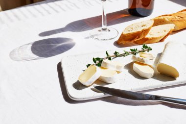 Lezzetli peynirli peynir ya da peynirli peynir, baget ve beyaz masa örtülü bir bardak şarap. Süt ürünleri. İtalyan, Fransız peyniri. Kahvaltı..