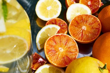 Yaz tazelenmiş limon kokteyli, buzlu ve olgun biyo turunçgiller, doğa arka planında çelik tepside. Organik Sicilya portakalları