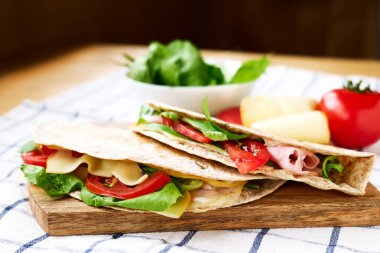 Mozarella peynirli, domatesli, jambonlu ve roket salatalı Piadina Romagnola. İtalyan ekmeği ya da açık sandviç. Seçici odak.