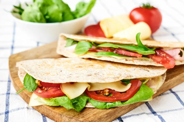 Mozarella peynirli, domatesli, jambonlu ve roket salatalı Piadina Romagnola. İtalyan ekmeği ya da açık sandviç. Seçici odak.