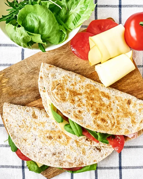 Mozarella peynirli, domatesli, jambonlu ve roket salatalı Piadina Romagnola. İtalyan ekmeği ya da açık sandviç. Seçici odak.