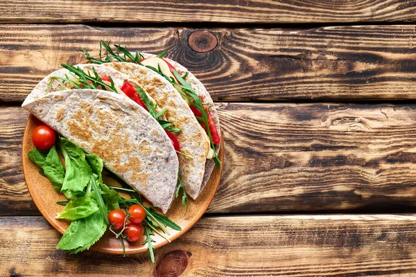 Mozzarella peynirli, domatesli, jambonlu ve roket salatalı Piadina Romagnola. İtalyan ekmeği ya da açık sandviç. Seçici odaklanma. Üst görünüm.