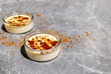 Krem karamelize kahverengi kamış şekeri ve gri mermer arka planda Fransız usulü tatlı. İki porsiyon lezzetli katalan kreması. Uzayı kopyala Seçici odak.