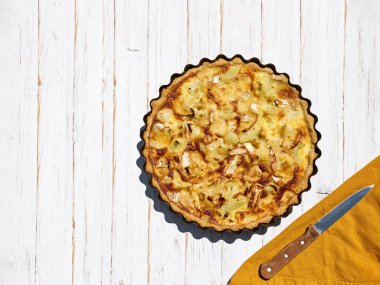 Beyaz ahşap arka planda ev yapımı karnabahar ve jambon kiş. Evde yemek pişirmek. Üst Manzara. Boşluğu kopyala