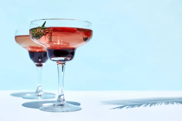 Fresh summer strawberry cocktail or mocktail on the table in the garden. Creative drink beverage on sunlight with shadows.