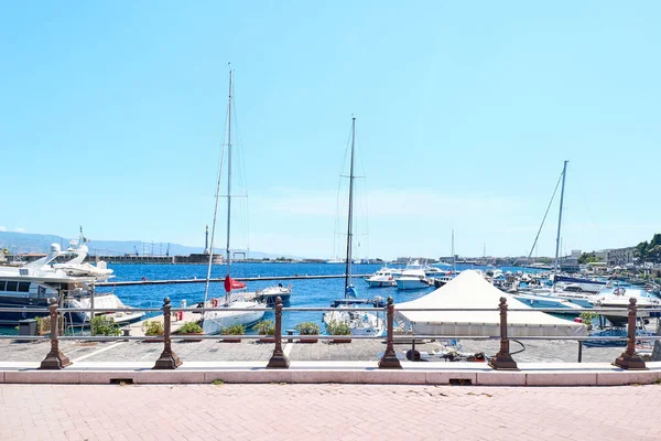 Messina, Sicilya, İtalya - 26 Nisan 2021: Bağlı tekneleri olan Messina Limanı, altın rengi Madonna della Lettera heykeli ve arka planda calabria kıyı şeridi.