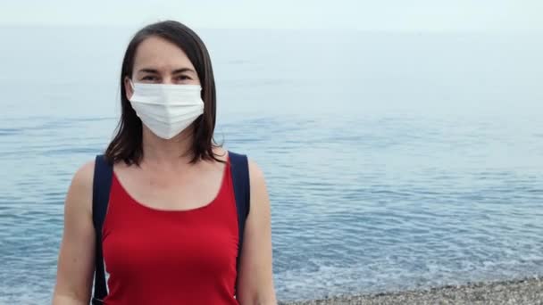 在验尸官病流行结束后的夏天，女人摘下了脸上的保护膜，在海滩上深深地吸了一口气. — 图库视频影像