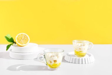 Sarı arka planda cam bardakta limonlu krema ya da dondurma. Geleneksel İtalyan limon tiramisu ya da granita tarifi. Lezzetli yaz tatlıları.