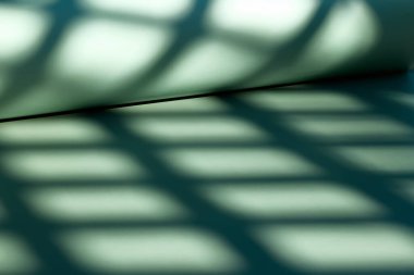 Soyut geometrik gölge. Açık yeşil tek renkli duvar kağıtları. Gölge ve ışık ile ürün sunumu için arkaplan.