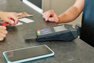 İşlem için POS terminali kullanan kredi kartıyla ödeme yapan tanınmayan bir kadın.