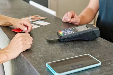 İşlem için POS terminali kullanan kredi kartıyla ödeme yapan tanınmayan bir kadın.