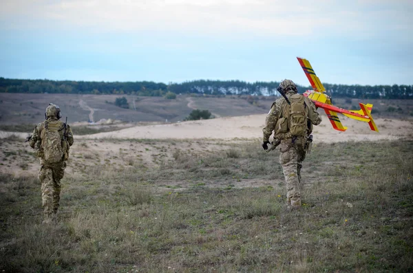 Dos soldados y avión no tripulado UAV en un desierto — Foto de Stock