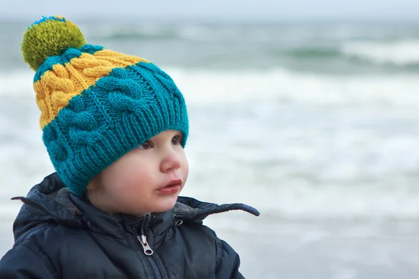 Jongen in kleur hoed op een strand — Stockfoto