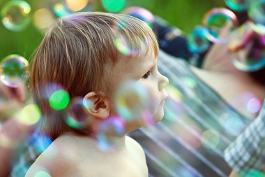 Sabun köpüğü arasında çocuk