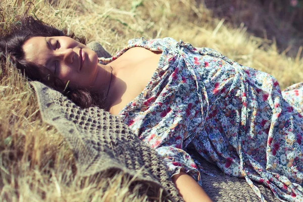 Jonge vrouw liggen op gele gras — Stockfoto