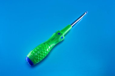 Mavi arka planda yeşil bir tornavida.