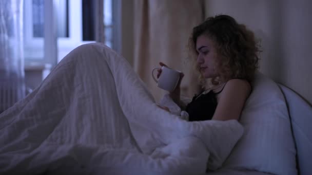 Uyumadan önce akıllı telefondan mesaj okuyan kadın — Stok video