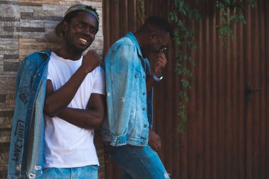 Arka plandaki tuğla duvarda mutlu bir Afrikalı var.