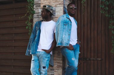 Arka plandaki tuğla duvarda mutlu bir Afrikalı var.