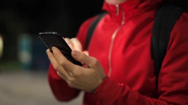 Parkta akıllı telefonu olan tanınmayan biri.