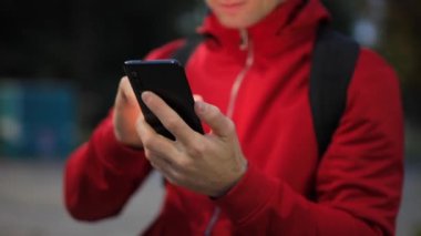Parkta akıllı telefonu olan tanınmayan biri.