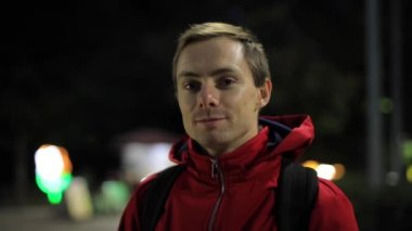 Şehirdeki kameraya gülümseyen mutlu adam.