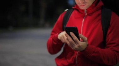 Parkta akıllı telefonu olan tanınmayan biri.