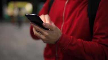 Parkta akıllı telefonu olan tanınmayan biri.